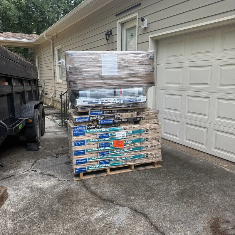 CertainTeed Landmark shingles, Shadow Ridge bundles and wrapped accessories beside a garage.