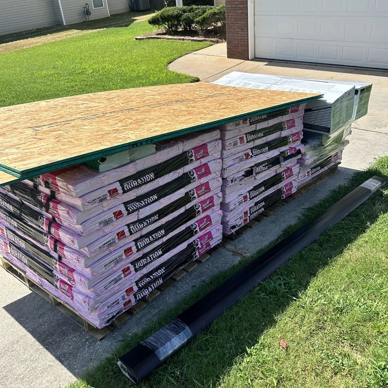 Owens Corning Duration shingles, roof decking and edge metal delivered to a driveway.