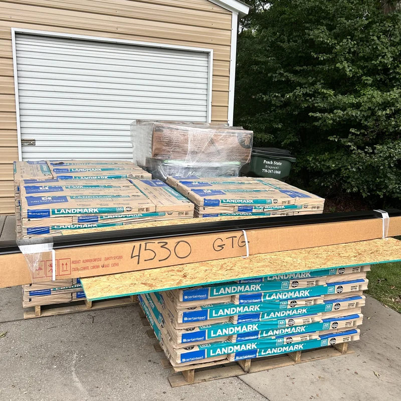 CertainTeed Landmark shingles, decking and edge metal stacked outside a garage.