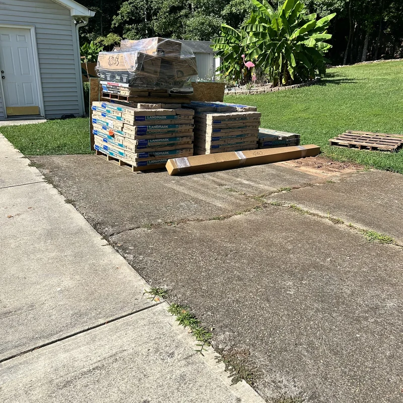 Pallets of CertainTeed Landmark shingles and roofing accessories delivered beside a home.