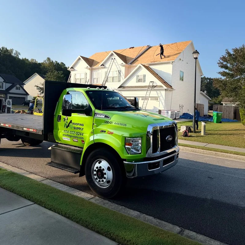 A+ Roofing Supply flatbed truck at a residential roofing jobsite.