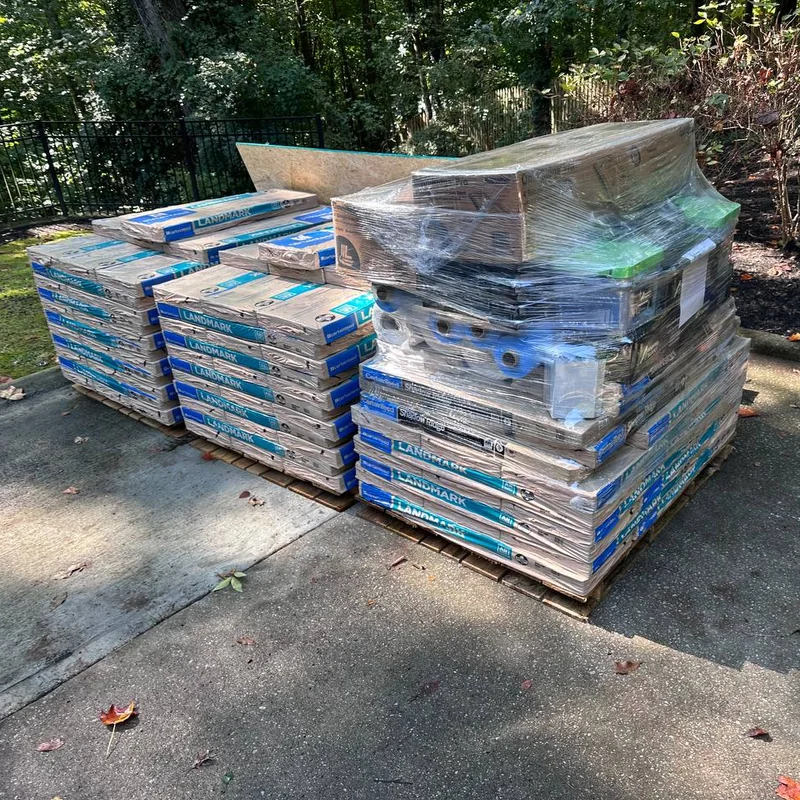 CertainTeed Landmark shingle pallets and wrapped roofing accessories on a residential driveway.