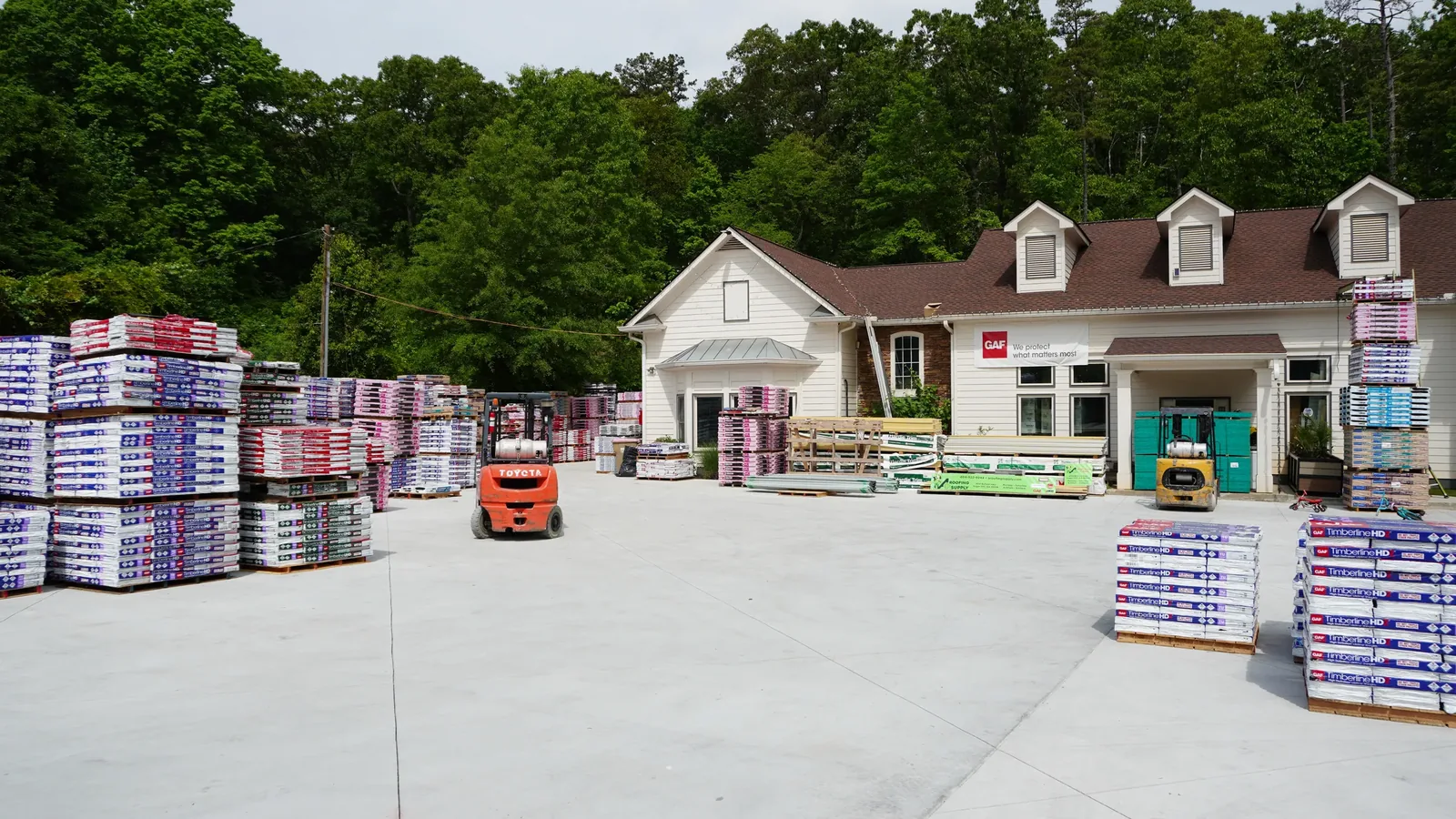 A+ Roofing Supply warehouse in Sugar Hill with roofing shingle pallets and forklifts